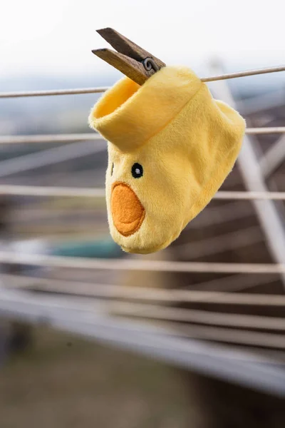 Baby sock with a funny duck figure - baby clothes on a clothesline