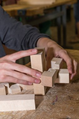 Person assembling wooden puzzle - wooden knot, devil knot, alexander knot