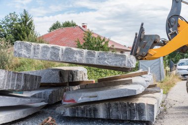 Tekerlek yükleyicili granit bloğu - inşaat alanında ön yükleyici