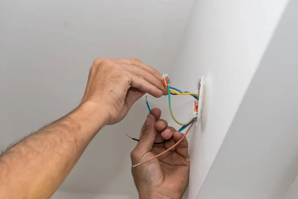 Electrician wiring a socket in the house - electrician closeup