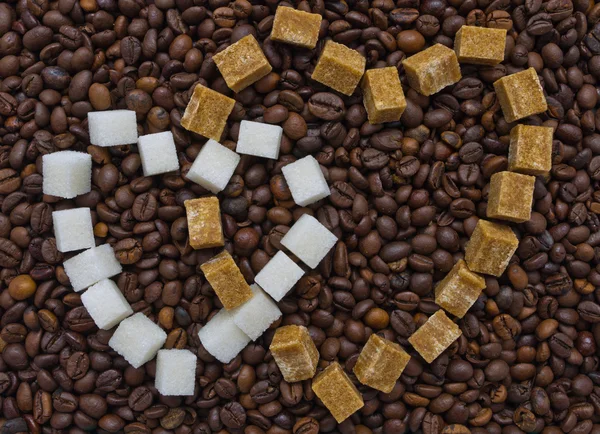 Lustige Zusammensetzung von Zucker in Form von zwei Herzen auf dem Hintergrund von Kaffeebohnen Stockfoto