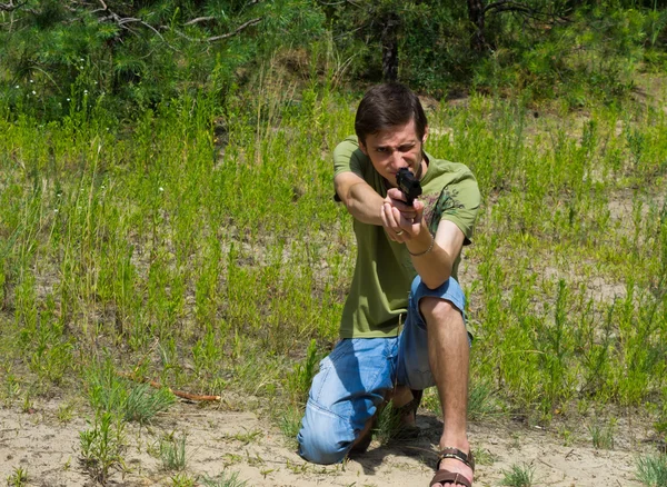 空気圧銃で狙いを定める若い男の肖像 ロイヤリティフリーのストック写真