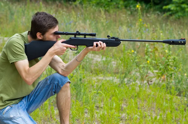 Young man taking aim with the air rifle — Stock Photo, Image