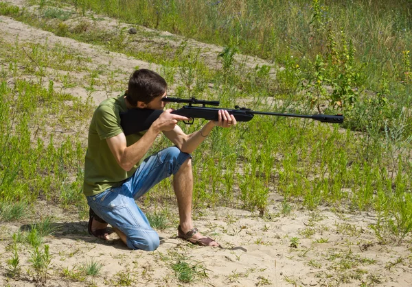 Young man taking aim with the air rifle — Stock Photo, Image