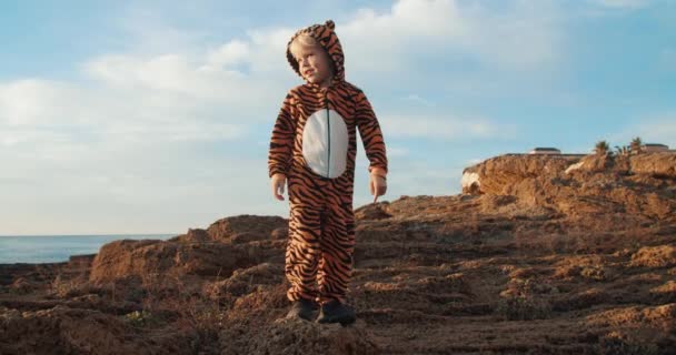 Милые дети в костюме тигра на солнечном рассвете у моря занимаются спортивными упражнениями — стоковое видео