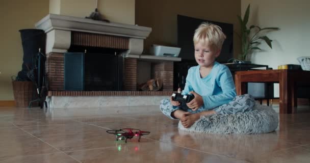 Chlapeček se ráno probudil a sedl si, aby si pohrál s novou hračkou létající dron — Stock video