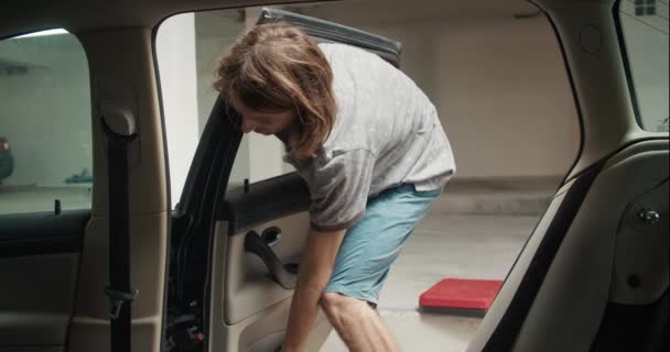 Hombre joven reemplazando la puerta del vehículo negro en el mantenimiento del coche de servicio — Vídeos de Stock