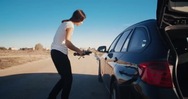 Jovem mulher tem pneu furo carro avaria durante a viagem na estrada do país — Vídeo de Stock
