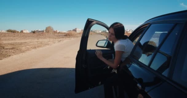 Joven hermosa mujer saliendo del coche y pone triángulo de advertencia — Vídeos de Stock