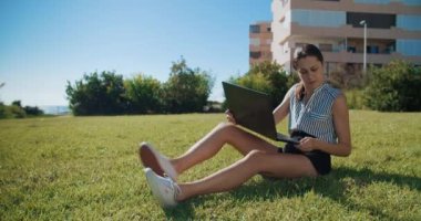 Dizüstü bilgisayarla çalışan ve dışarıda cep telefonuyla konuşan serbest çalışan bir kadın.