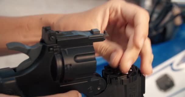 Чоловіки крупним планом заправили револьвер пневматичної гармати на відкритому повітрі — стокове відео