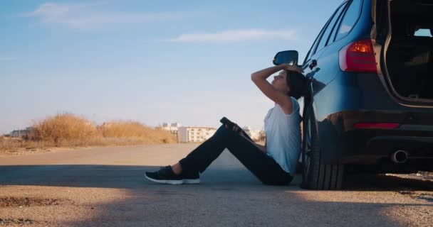 Aracın yanında oturan kadın uyarı üçgeni acil durum ışıklarıyla — Stok video