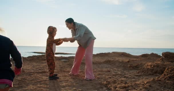 Счастливая семья танцует утром на рассвете один ребенок в костюме тигра — стоковое видео