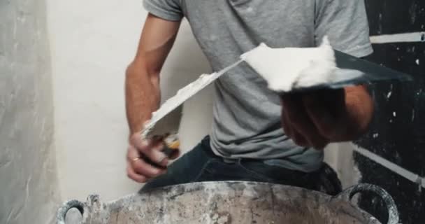 Close up man handen brengt cement oplossing met troffel op spatel nivellering muur — Stockvideo