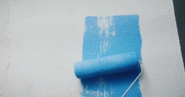 Gros plan de peinture bleue appliquée sur le mur blanc avec des réparations à domicile rouleau — Video