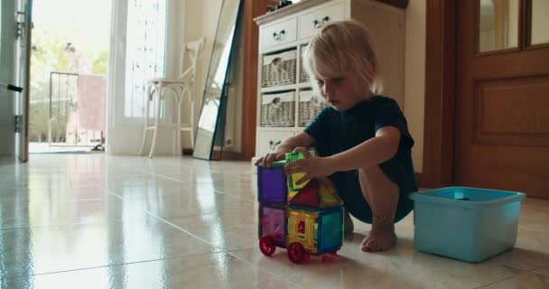 Carina bambina di 2 anni che gioca con il giocattolo magnetico del costruttore — Video Stock