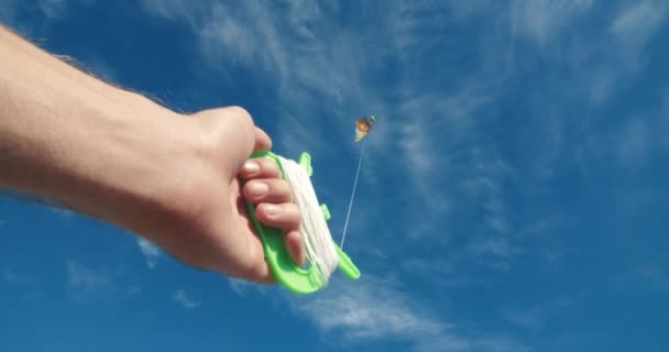 POV camera jonge man hand houden vlieger met blauwe bewolkte hemel als achtergrond — Stockvideo