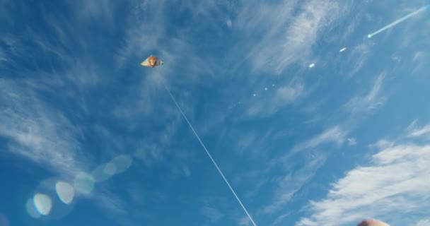 Kamera POV tangan pemuda memegang layang-layang dengan langit biru mendung sebagai latar belakang — Stok Video