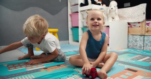 Bambini svegli che giocano con i giocattoli del tuck del fuoco nella stanza dei bambini la sera — Video Stock