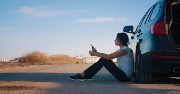 Menina chamada chateada telefone após um acidente sentado de carro com um pneu furado — Vídeo de Stock