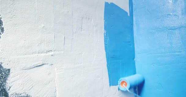 Primer plano de pintura azul aplicada a la pared blanca con reparaciones de casas de rodillos — Vídeo de stock