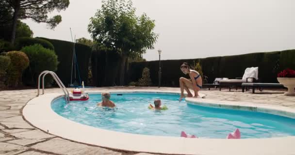 Счастливая семья в бассейне на летних каникулах путешествует в Испанию — стоковое видео