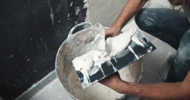 Kapalı adam elleri duvar seviyelendirme spatula üzerinde mala ile çimento çözeltisi uygular