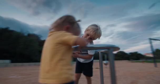 Glückliche Kinder drehen sich auf Karussellschaukel und lachen bei Sonnenuntergang — Stockvideo