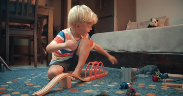 Bambino bambino bambino che gioca con la strada giocattolo ferroviario in legno costruendo il ponte — Video Stock