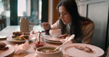 Genç ve çekici bir kadın İspanya 'ya giderken restoranda çorba içiyor.