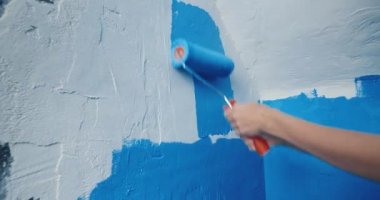 Yuvarlak ev tamiri ile beyaz duvara uygulanan mavi boyayı kapat
