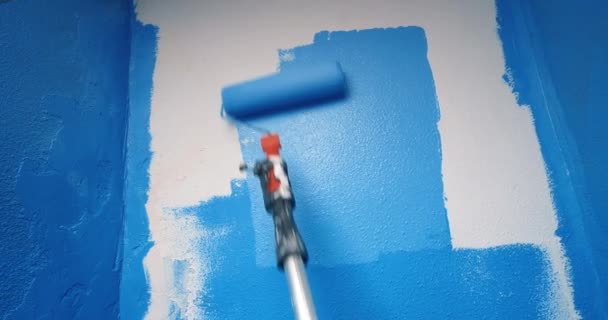Nahaufnahme von blauer Farbe an weißer Wand mit Reparaturwalze — Stockvideo