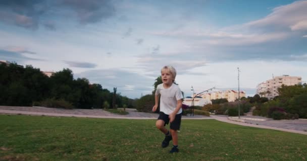 Criança em câmera lenta jogando futebol correndo e chuta a bola para a câmera — Vídeo de Stock