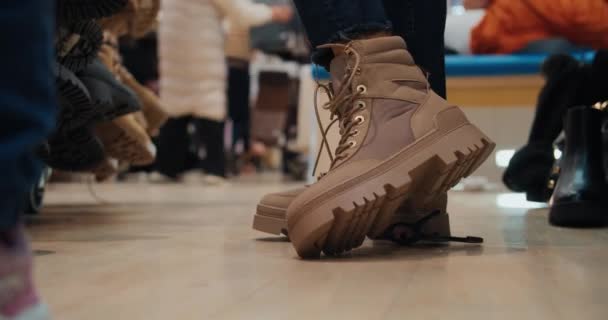 Mujer durante las compras intenta zapatos nuevos piernas de cerca — Vídeo de stock