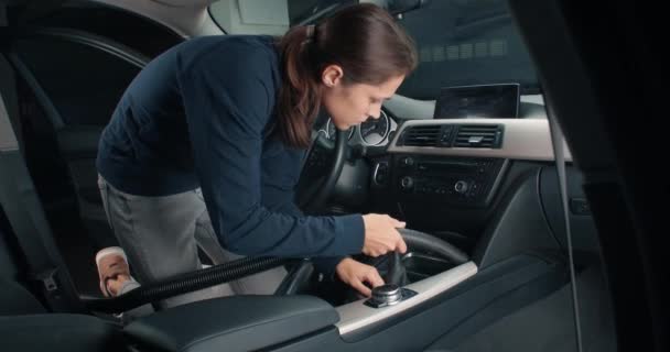 Mladá žena dělá interiér vozidla detaily s vysavačem — Stock video