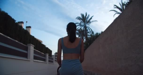 Tânără femeie atractivă de mers pe jos cu cărucior pentru copii în seara de vară în vacanță — Videoclip de stoc