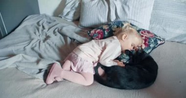 Küçük kız oturma odasında kara kediyle yatıyor.
