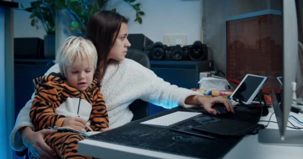 Atraktivní žena na volné noze pracující před počítačem doma s dítětem — Stock video