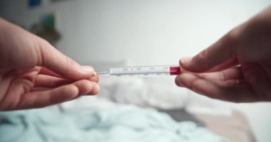 Erkek eller çok yüksek sıcaklıkta analog termometreyi tutuyor.