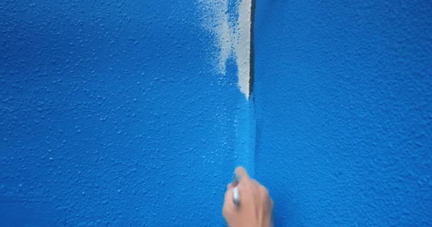 Mujer mano primer plano pintura esquina de la pared con pintura azul con pincel — Vídeo de stock