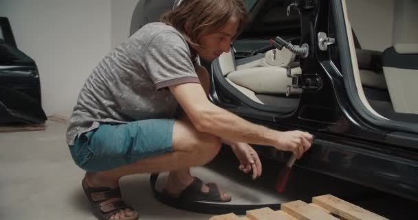 Servicio hombre mecánico atornillar pernos en la carrocería del vehículo en el garaje haciendo reparación de automóviles — Vídeo de stock