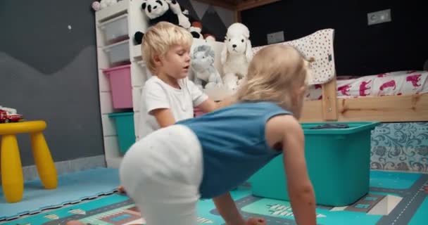 Leuke kinderen baby jongen trekt uit een doos van speelgoed in de slaapkamer op de avond — Stockvideo