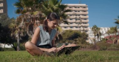 Dizüstü bilgisayarla çalışan ve dışarıda cep telefonuyla konuşan serbest çalışan bir kadın.