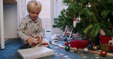 Mutlu çocuklar, kardeşlerim Noel hediyelerini çam ağacının altında buluyor.