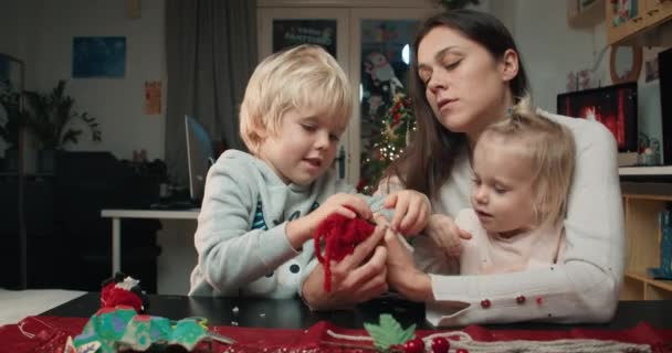 Famille faisant ensemble cadeau bricolage artisanal pour la soirée de Noël à la maison — Video