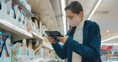Aile için süpermarketten alışveriş yapan genç bir kadının portresi
