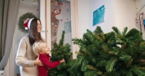 快乐的家庭装饰圣诞树，一起挂在松树顶上 — 图库视频影像