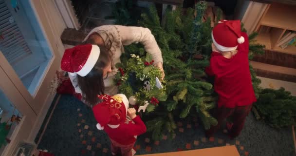 Vista superior feliz familia instalando el árbol de Navidad en vacaciones de invierno — Vídeo de stock