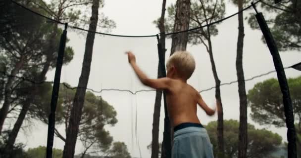 Heureux enfants mignons sautant sur le trampoline sur l'environnement rustique — Video