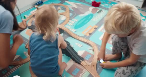 Familj tillsammans mor och barn leker med leksaker i sovrummet — Stockvideo